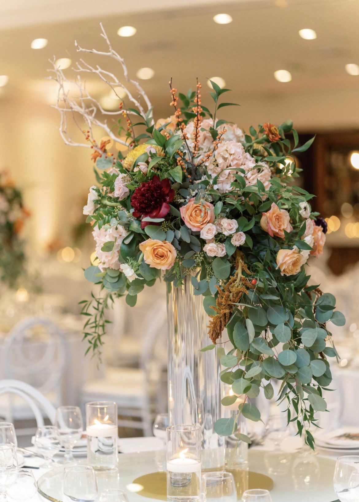 Tall lush reception centerpiece of roses and greenery