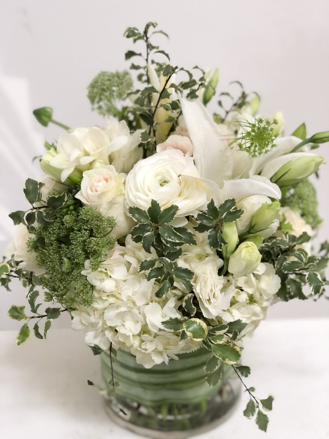 Organic garden-style arrangement of white blooms and greenery